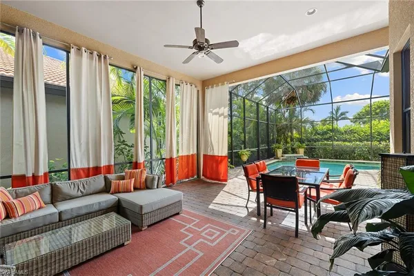 a living room with patio furniture and a floor to ceiling window