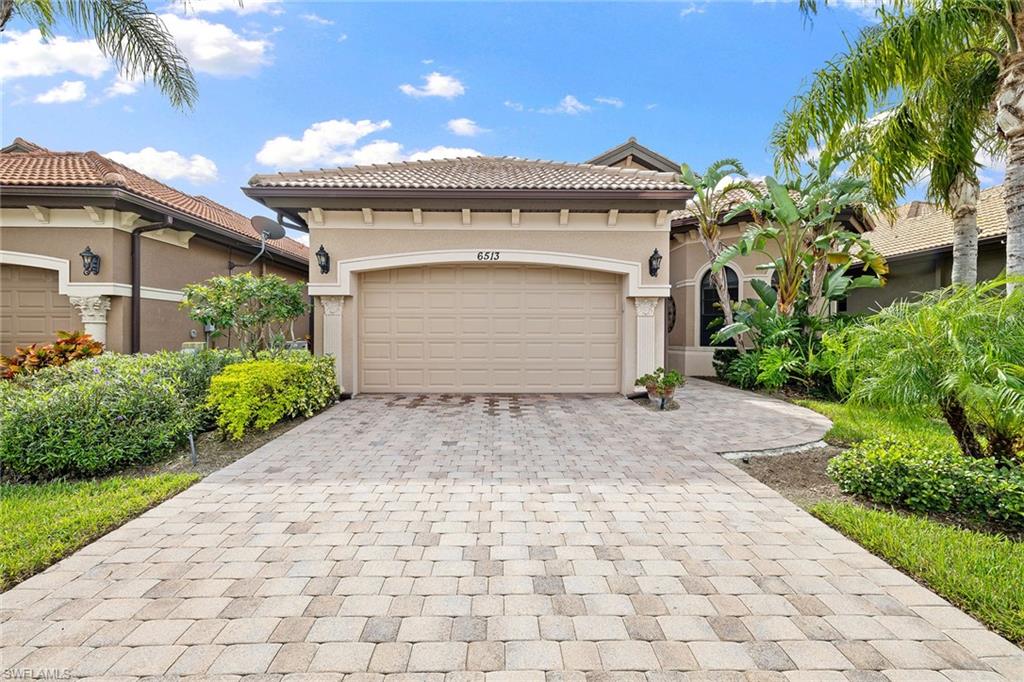 6513 Caldecott Drive Naples, FL 34113 - Photo 6 of 33 a front view of a house with a yard and garage