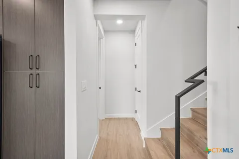 an empty room with wooden floor ceiling fan and windows