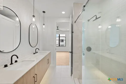 a bathroom with a sink a mirror a vanity and shower