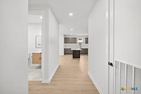 a kitchen with stainless steel appliances kitchen island granite countertop a refrigerator and a sink