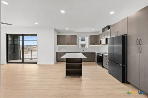 a kitchen with refrigerator cabinets and wooden floor
