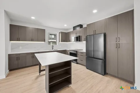 a kitchen with refrigerator cabinets and wooden floor