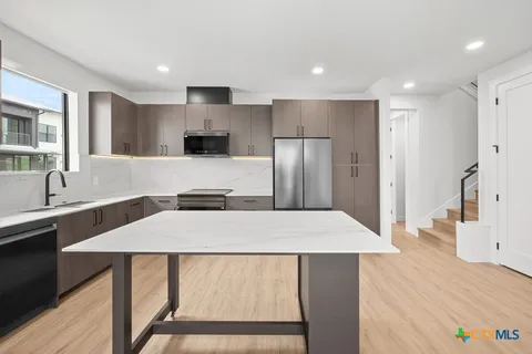 a kitchen with stainless steel appliances a refrigerator and a stove