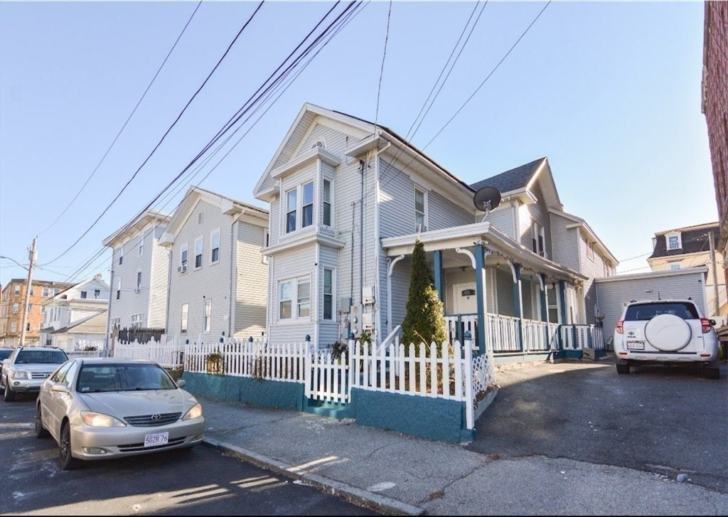 94 Summer Street Lawrence, MA 01840 - Photo 1 of 28 a view of a white house with a small yard and plants