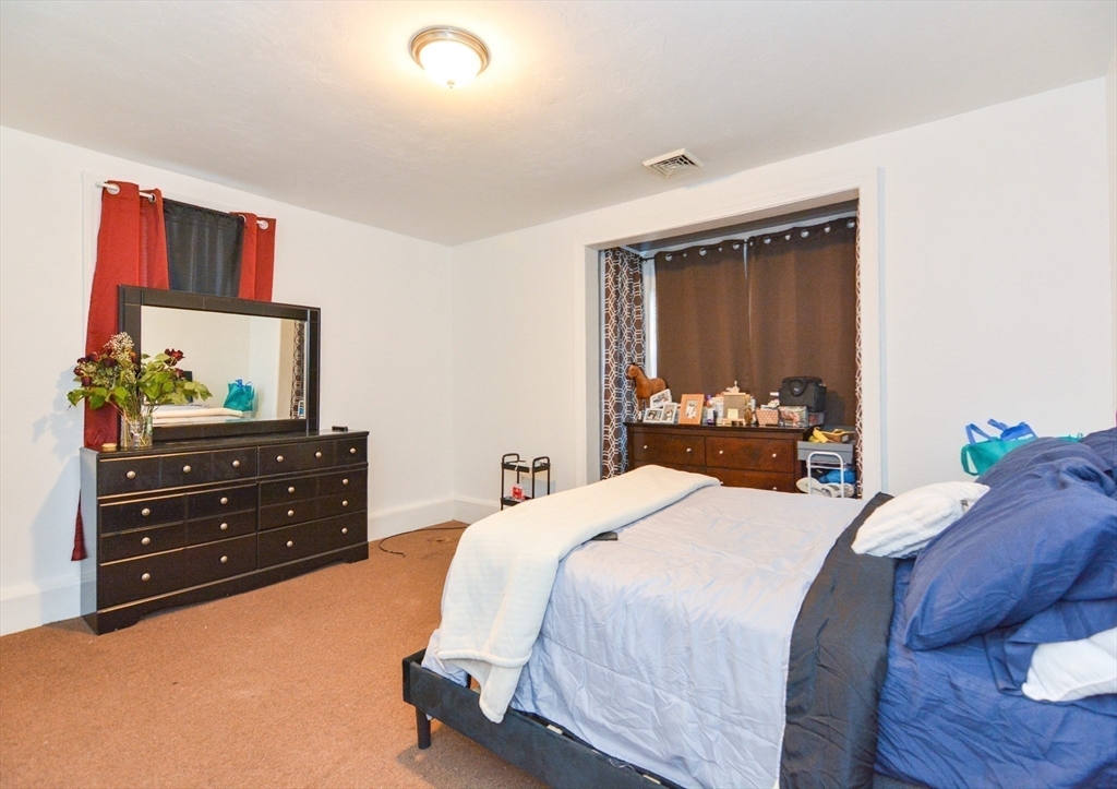 94 Summer Street Lawrence, MA 01840 - Photo 14 of 28 a bedroom with a bed and a dresser