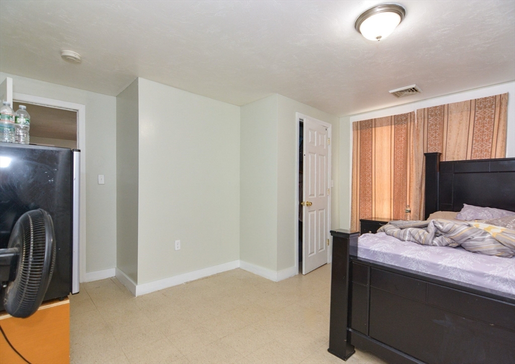 94 Summer Street Lawrence, MA 01840 - Photo 17 of 28 a bedroom with a bed and wooden floor