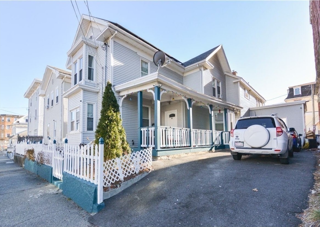 94 Summer Street Lawrence, MA 01840 - Photo 2 of 28 a white house with a small yard and wooden fence