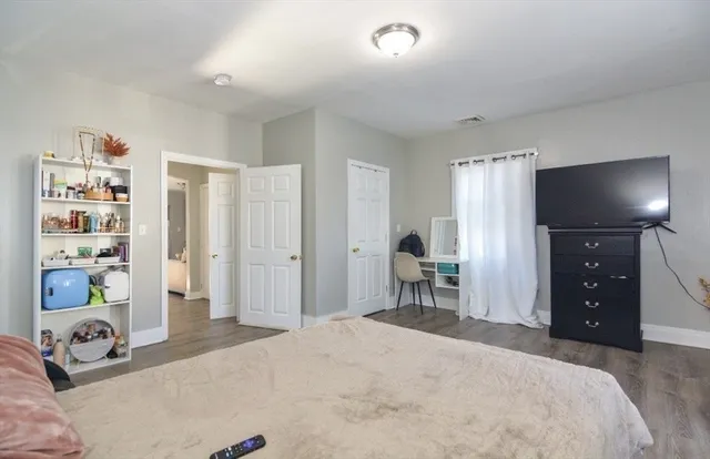 a bedroom with a bed and a large mirror