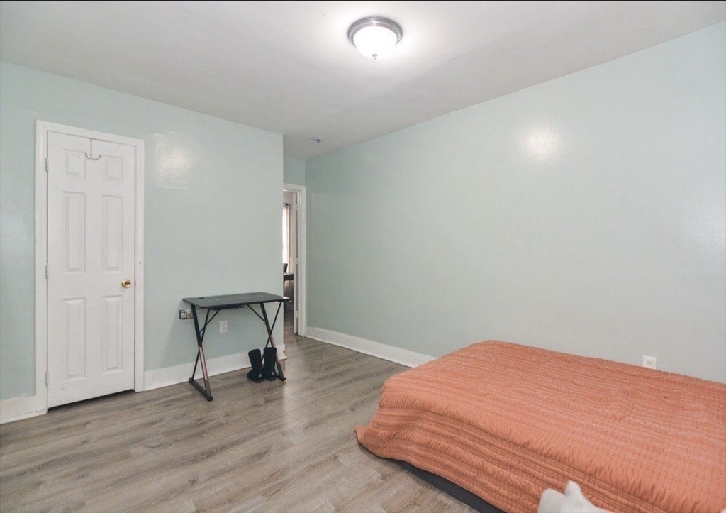 94 Summer Street Lawrence, MA 01840 - Photo 25 of 28 a bedroom with a bed and a table in it