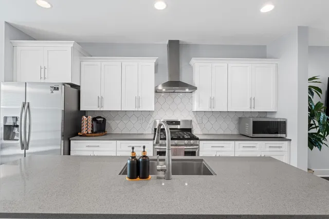 a kitchen with stainless steel appliances a stove a sink a refrigerator and cabinets
