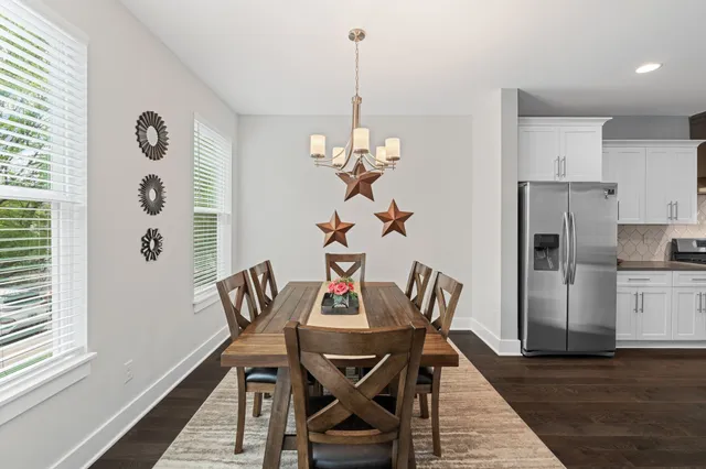 a view of a dining room with furniture wooden floor and a chandelier