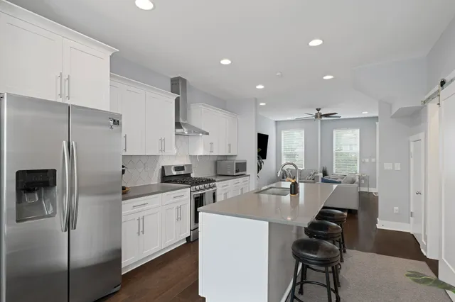 a kitchen with white cabinets and stainless steel appliances