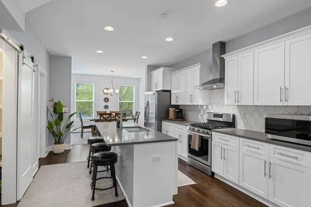 a kitchen with white cabinets and stainless steel appliances