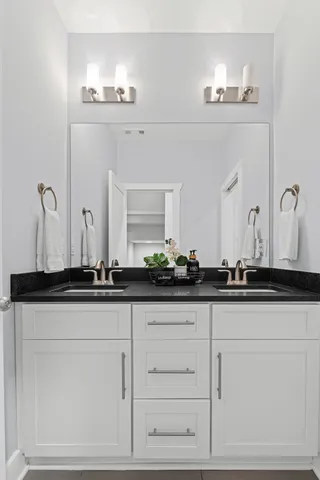 a bathroom with white cabinets and a sink