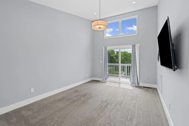 a view of a livingroom with wooden floor a ceiling fan and window