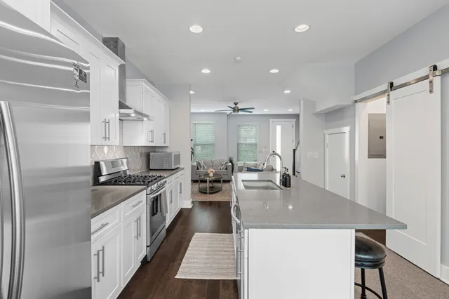 a open kitchen with stainless steel appliances granite countertop a lot of counter space and wooden floor