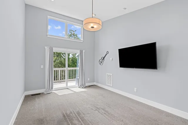 a view of an empty room with a flat screen tv and a window