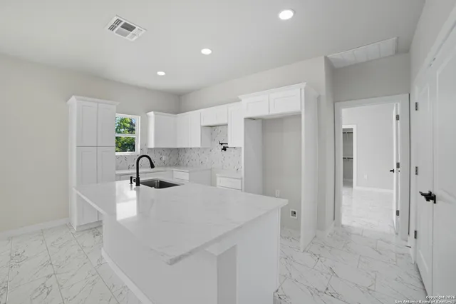 a kitchen with a sink cabinets and refrigerator