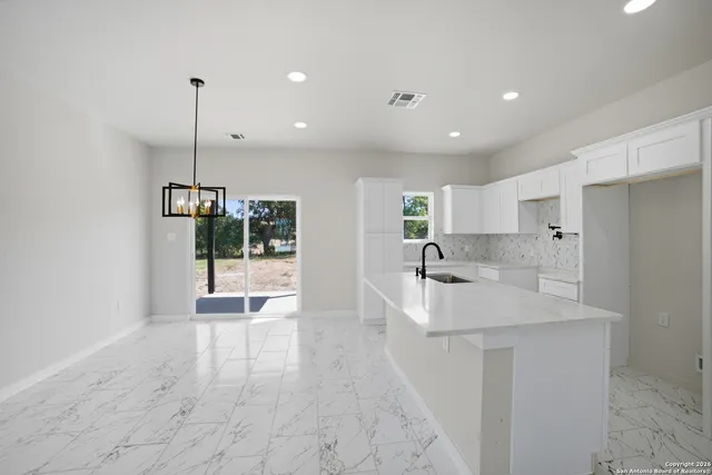 a kitchen with stainless steel appliances granite countertop a sink a refrigerator and a granite counter tops