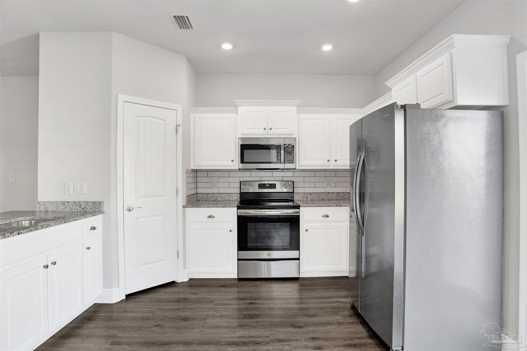 12295 Pinfish Road Pensacola, FL 32506 - Photo 12 of 34 a kitchen with stainless steel appliances white cabinets and a refrigerator