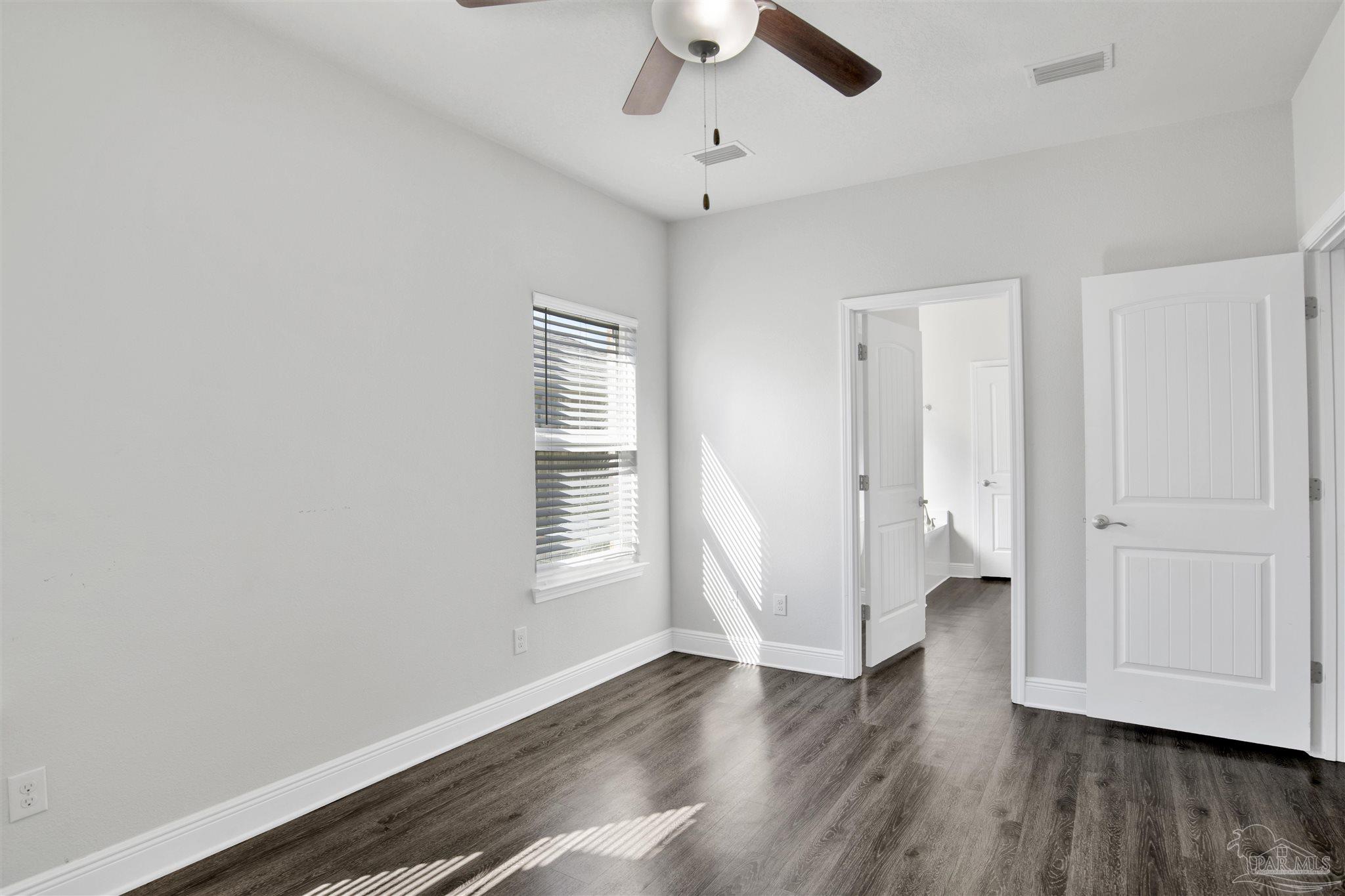 12295 Pinfish Road Pensacola, FL 32506 - Photo 18 of 34 an empty room with wooden floor and windows