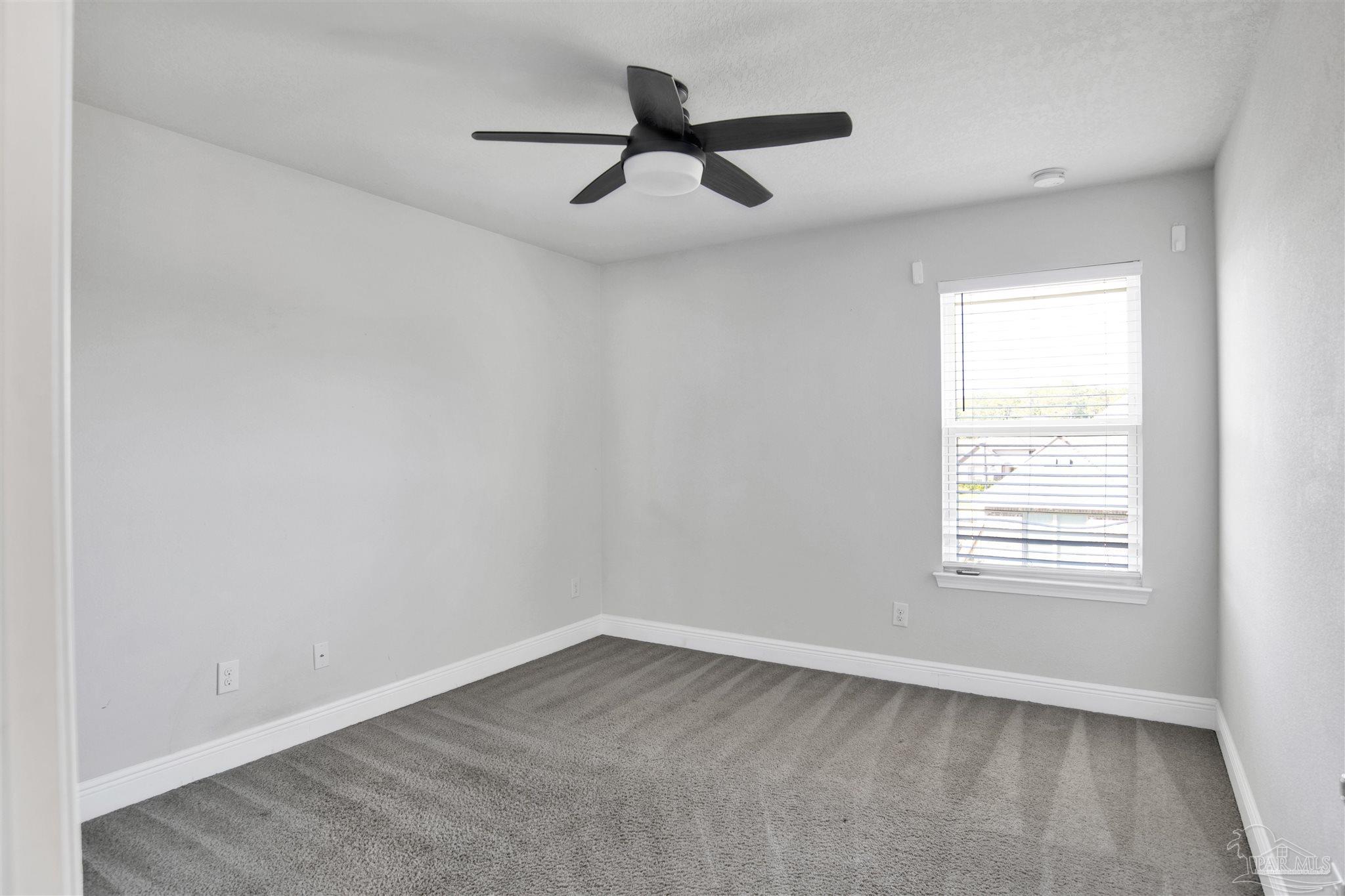 12295 Pinfish Road Pensacola, FL 32506 - Photo 28 of 34 an empty room with a window and a ceiling fan