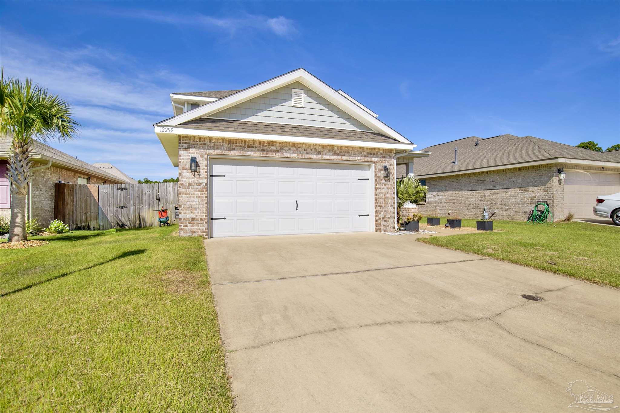 12295 Pinfish Road Pensacola, FL 32506 - Photo 3 of 34 a front view of a house with a yard and garage