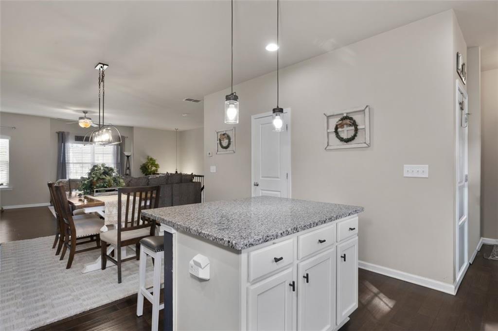 4180 Chatham Ridge Drive Buford, GA 30518 - Photo 13 of 43 a kitchen with a table chairs and chandelier