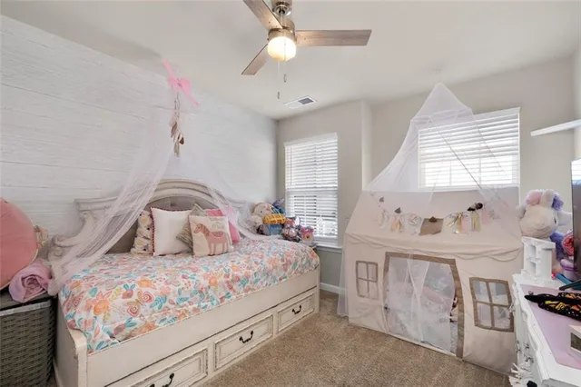 a bedroom with a bed a chandelier and dresser