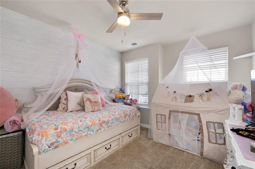 4180 Chatham Ridge Drive Buford, GA 30518 - Photo 20 of 43 a bedroom with a bed a chandelier and dresser