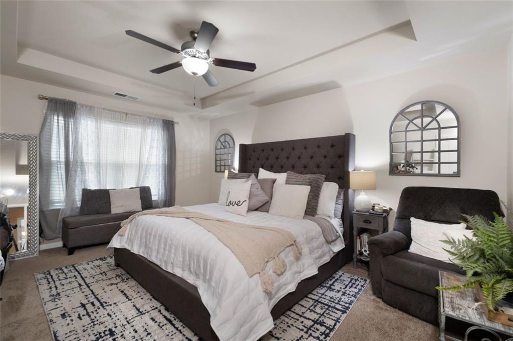 4180 Chatham Ridge Drive Buford, GA 30518 - Photo 25 of 43 a spacious bedroom with a bed a couch and a large window