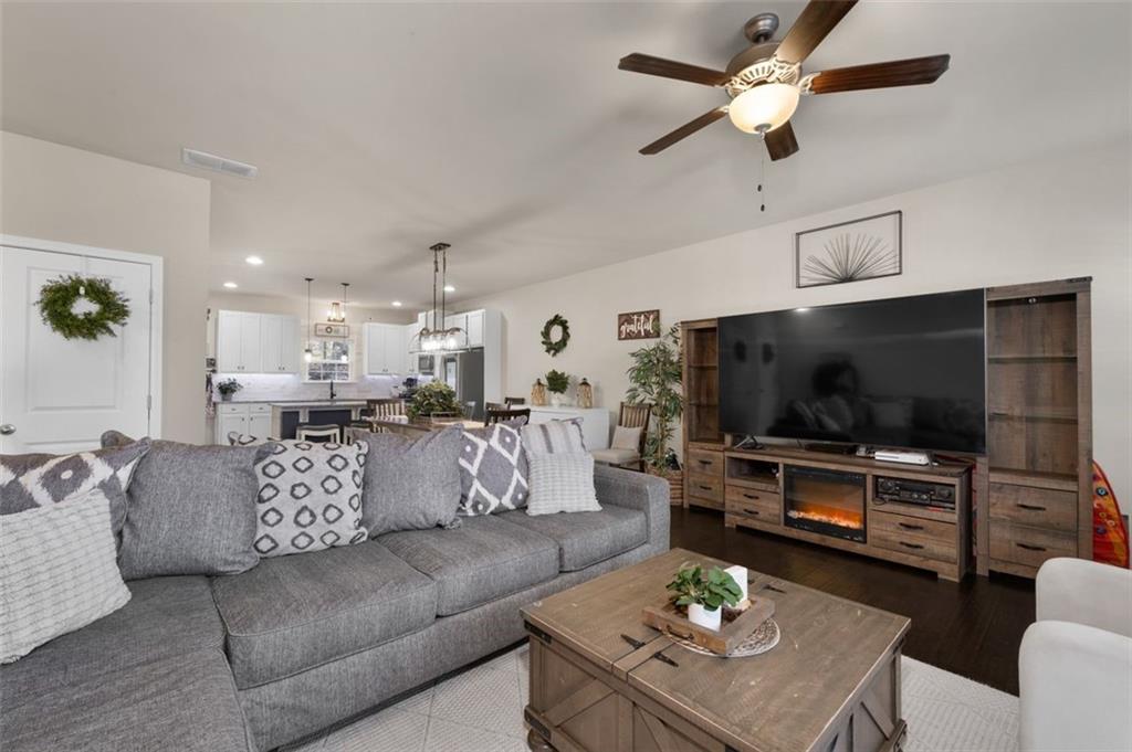 4180 Chatham Ridge Drive Buford, GA 30518 - Photo 8 of 43 a living room with furniture a flat screen tv and kitchen view