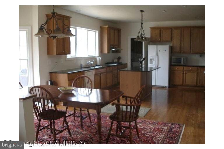 7201 Wesley Road Springfield, VA 22150 - Photo 7 of 11 a kitchen with a dining table chairs and refrigerator