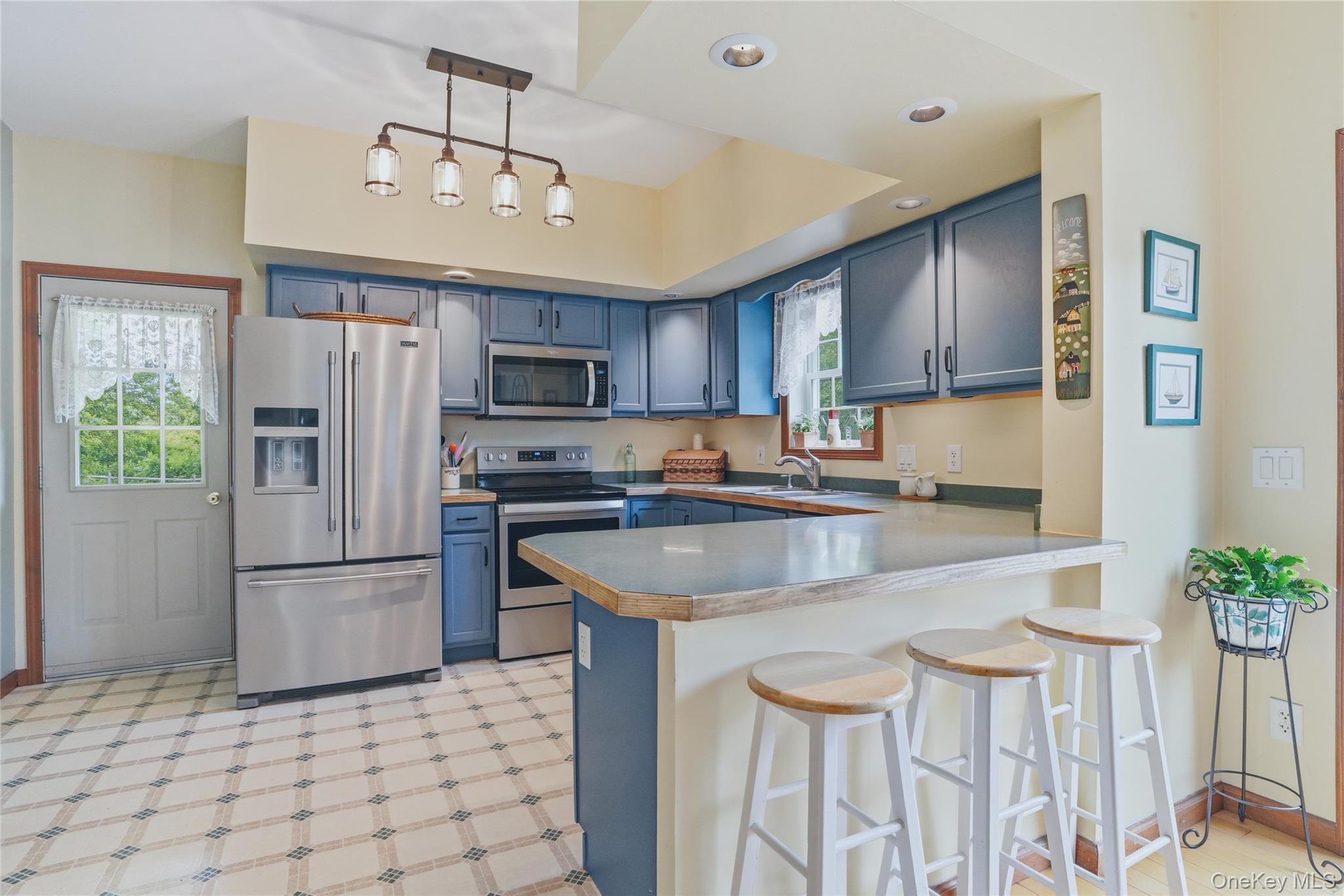 226 Cart Road, Unit C Dover Plains, NY 12522 - Photo 16 of 47 Kitchen with blue cabinets, stainless steal appliances and bar height counter with seating