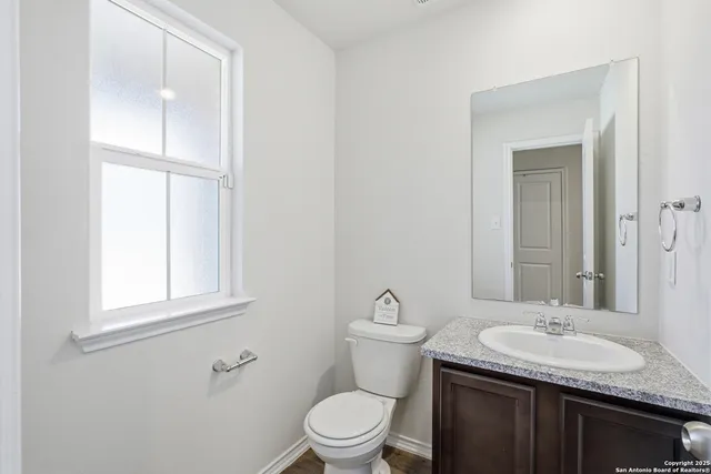 a bathroom with a granite countertop sink toilet and a mirror