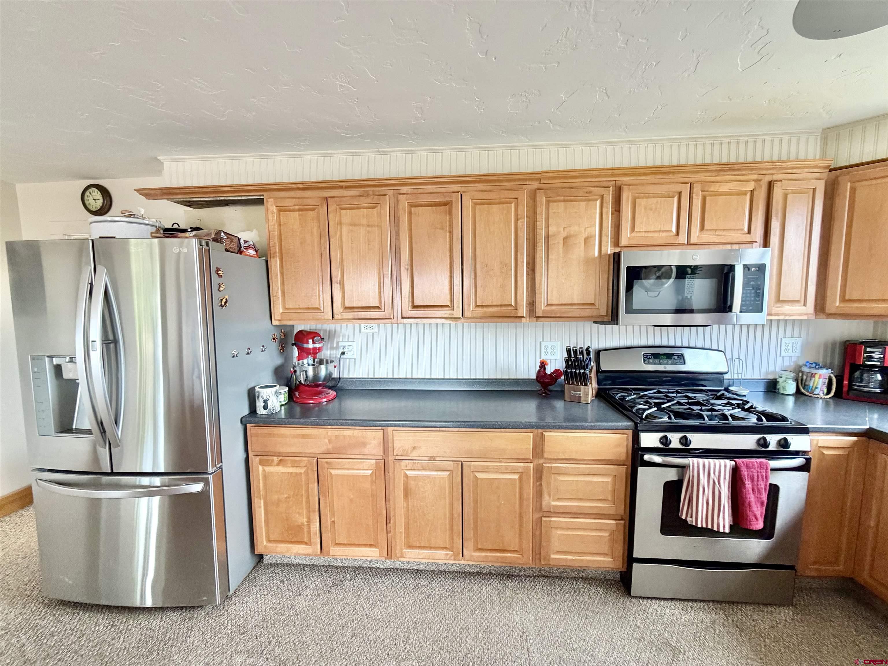 3998 5500th Road Olathe, CO 81425 - Photo 34 of 45 a kitchen with stainless steel appliances a refrigerator stove and microwave