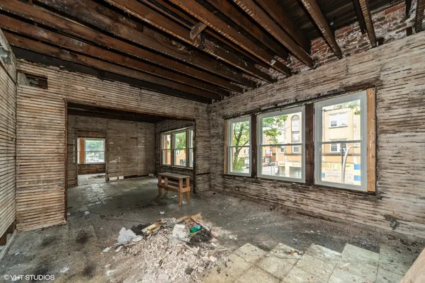 a view of an empty room with wooden floor and a chair