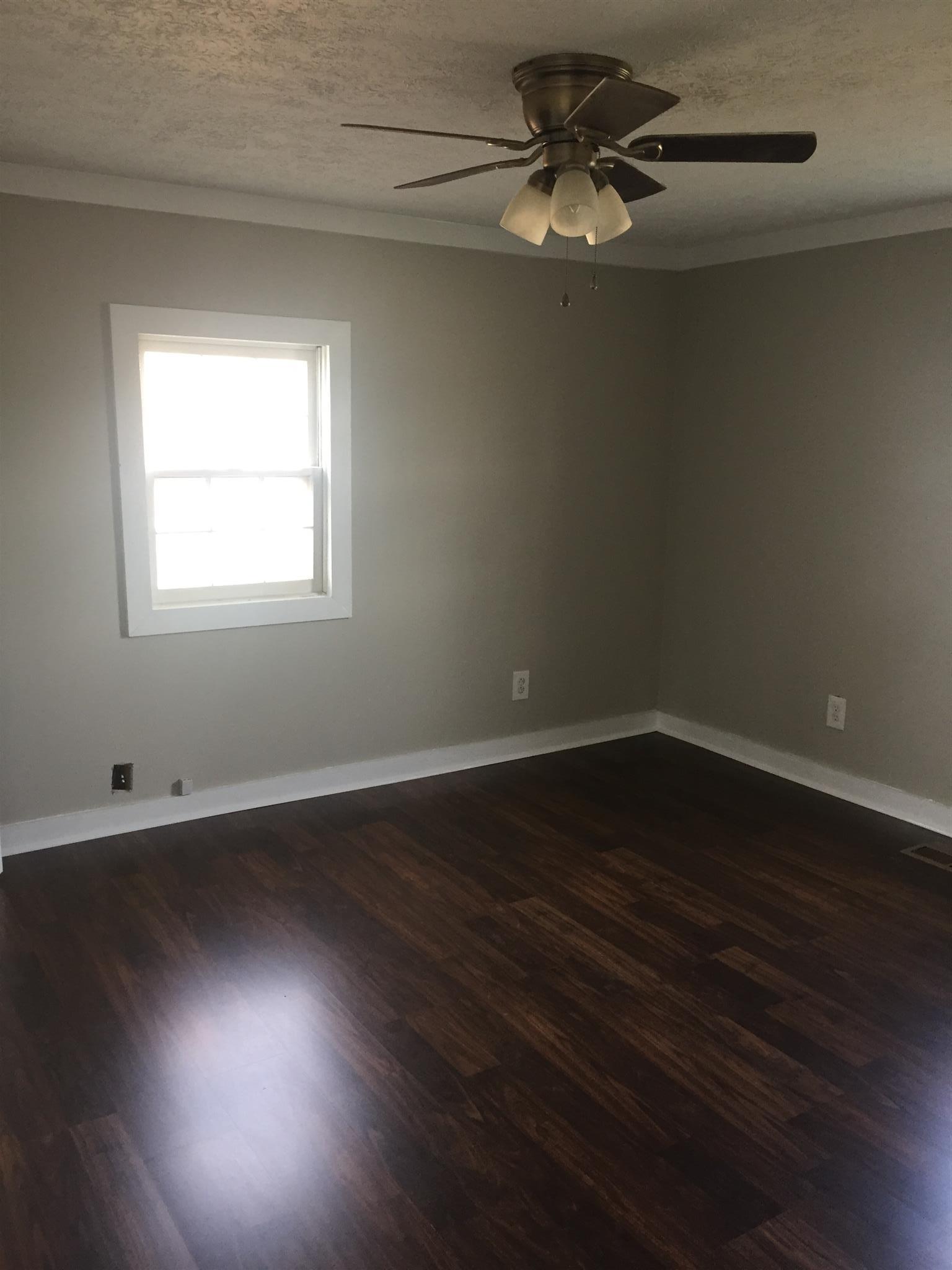 506 Dorris Road Portland, TN 37148 - Photo 6 of 8 a view of an empty room with wooden floor and a window