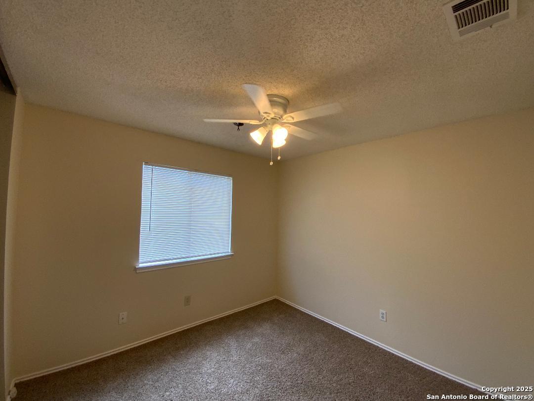 10126 Galesburg San Antonio, TX 78250 - Photo 15 of 17 an empty room with a window and a ceiling fan