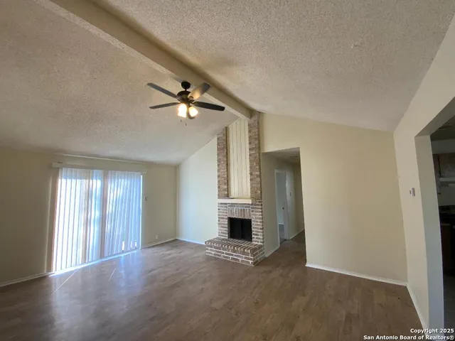an empty room with windows and a fireplace
