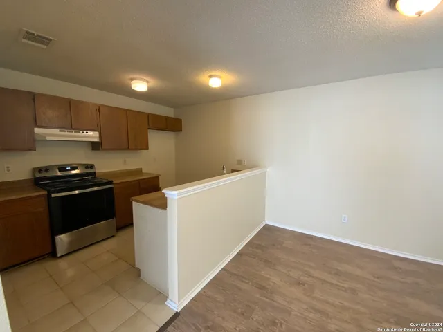a kitchen with a refrigerator and a stove top oven