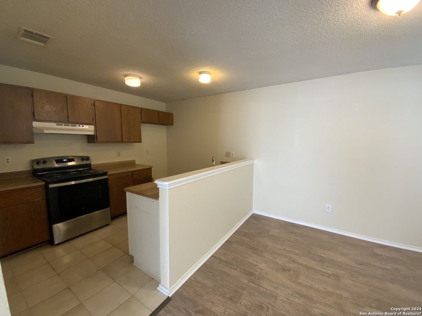 10126 Galesburg San Antonio, TX 78250 - Photo 6 of 17 a kitchen with a refrigerator and a stove top oven