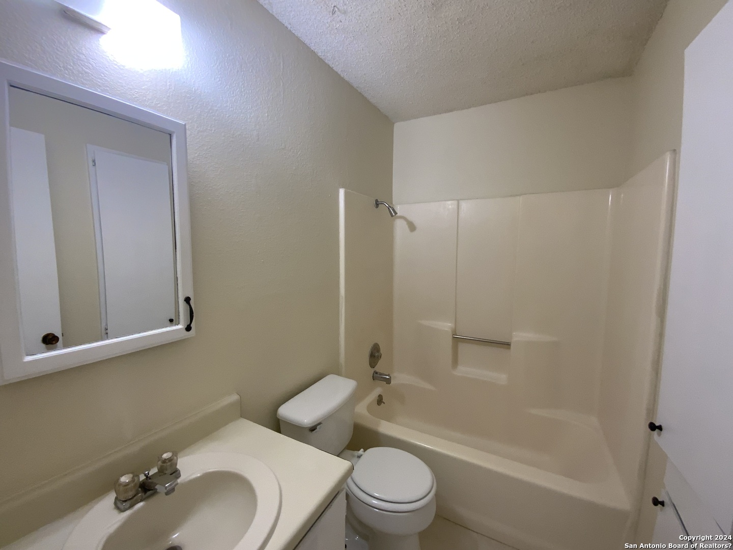 10126 Galesburg San Antonio, TX 78250 - Photo 10 of 17 a bathroom with a bathtub shower sink mirror vanity and toilet