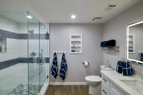 a bathroom with a granite countertop sink a toilet and a mirror