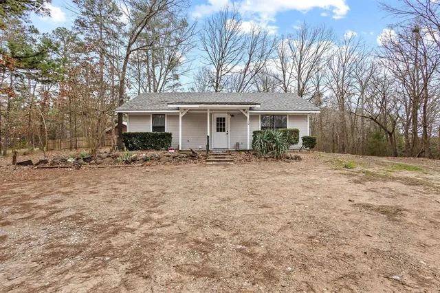 a front view of house with yard and trees around