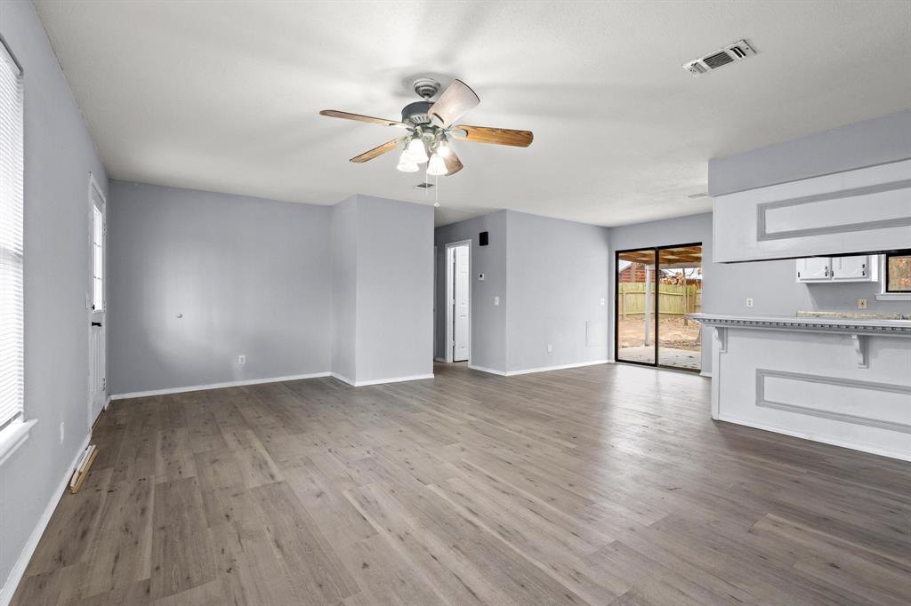 206 County Road Powderly, TX 75473 - Photo 5 of 31 a view of an empty room with a window and wooden floor