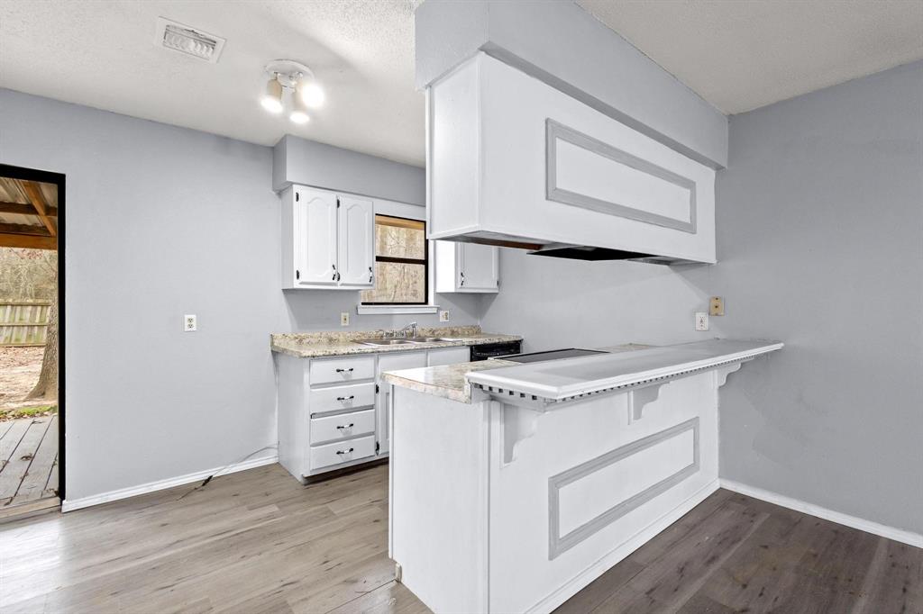 206 County Road Powderly, TX 75473 - Photo 8 of 31 a kitchen with a stove window and cabinets