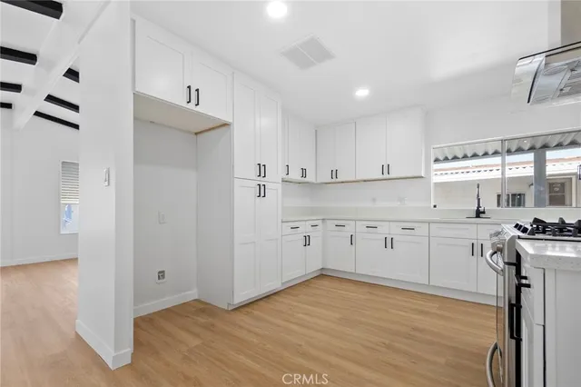 a kitchen with stainless steel appliances granite countertop a sink stove and cabinets