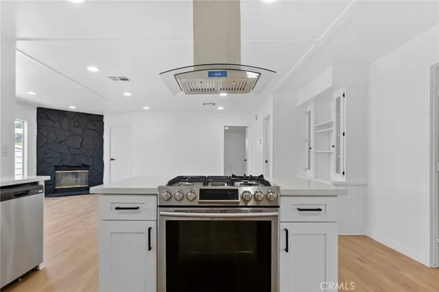 a kitchen with stainless steel appliances a sink cabinets and wooden floor